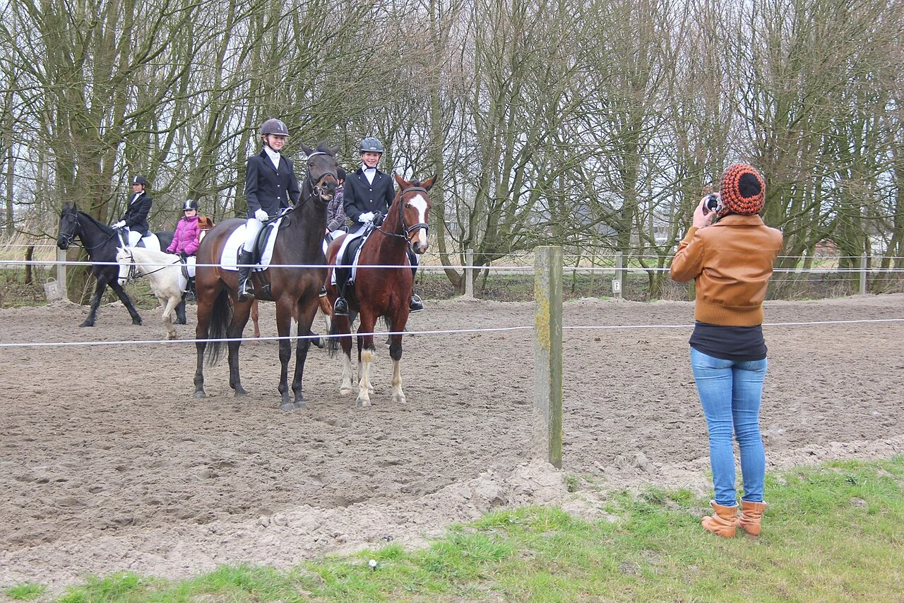 Dressage riders and family members sharing a relaxed moment at a local show