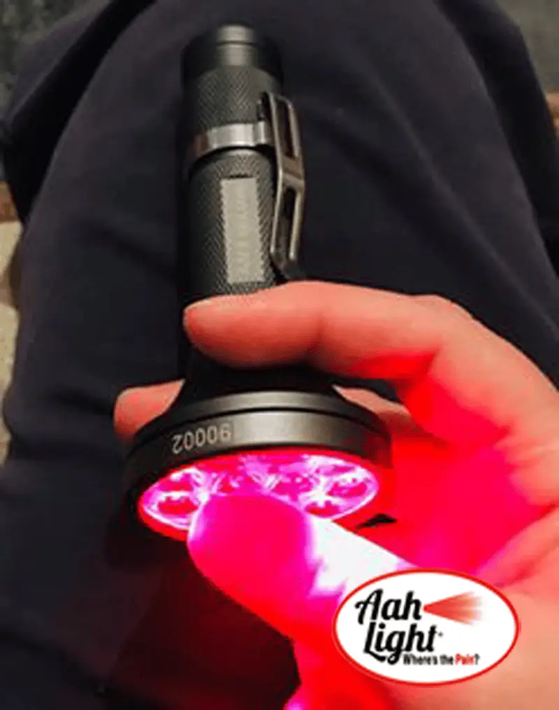 AAH Light PBM torch glowing deep red as it is held against the skin during a treatment session