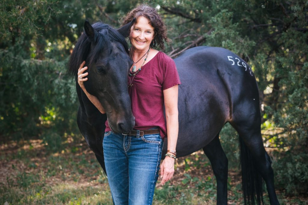 Kathy Pike, founder of The Academy for Coaching with Horses, with her horse outdoors