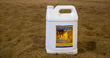 ARENACLEAR gallon jug standing in a treated field for dust and mud control