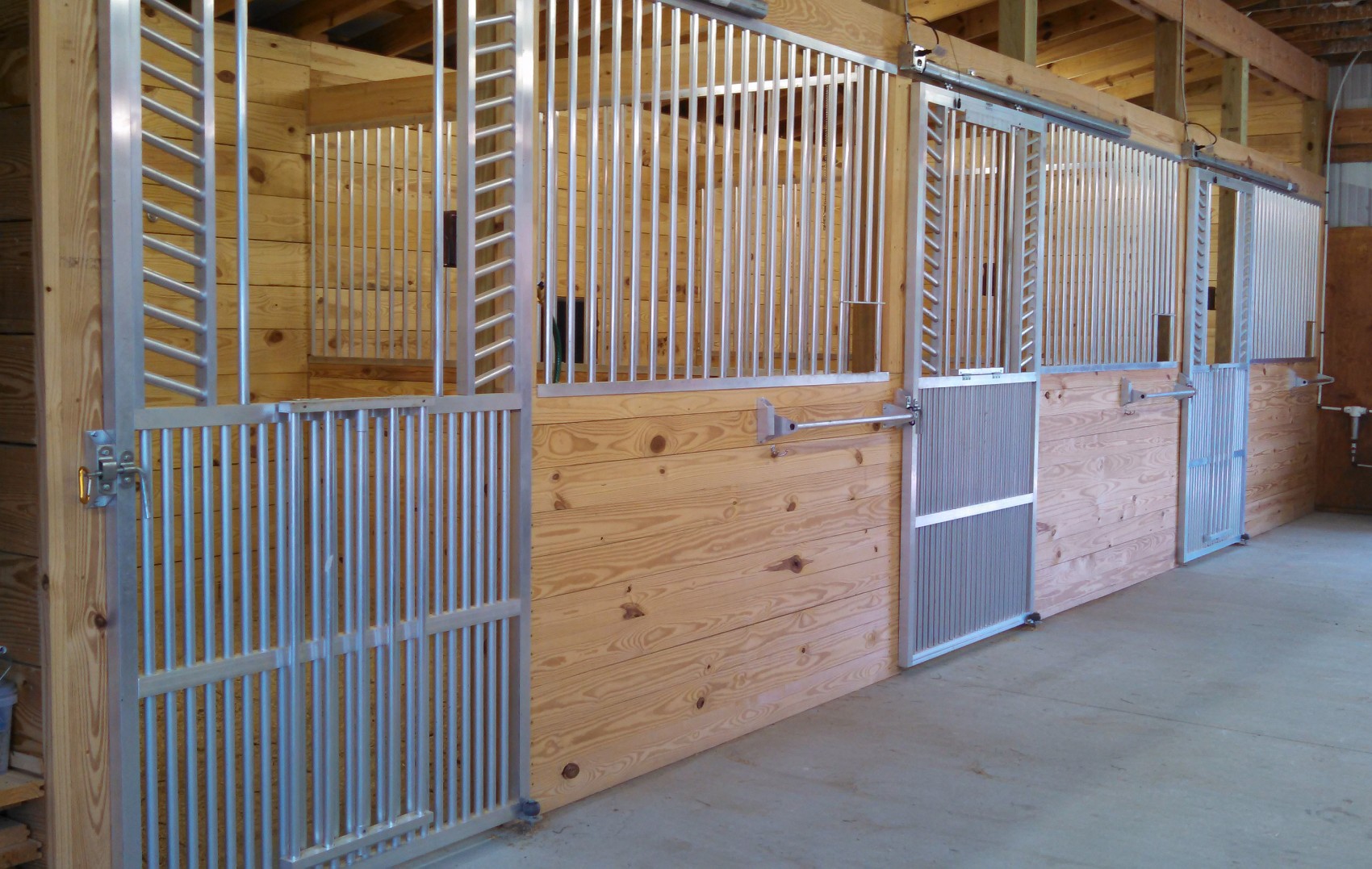 Aluminum horse stall fronts with sliding doors installed at Bella Terra Farm by Armour Horse Stalls