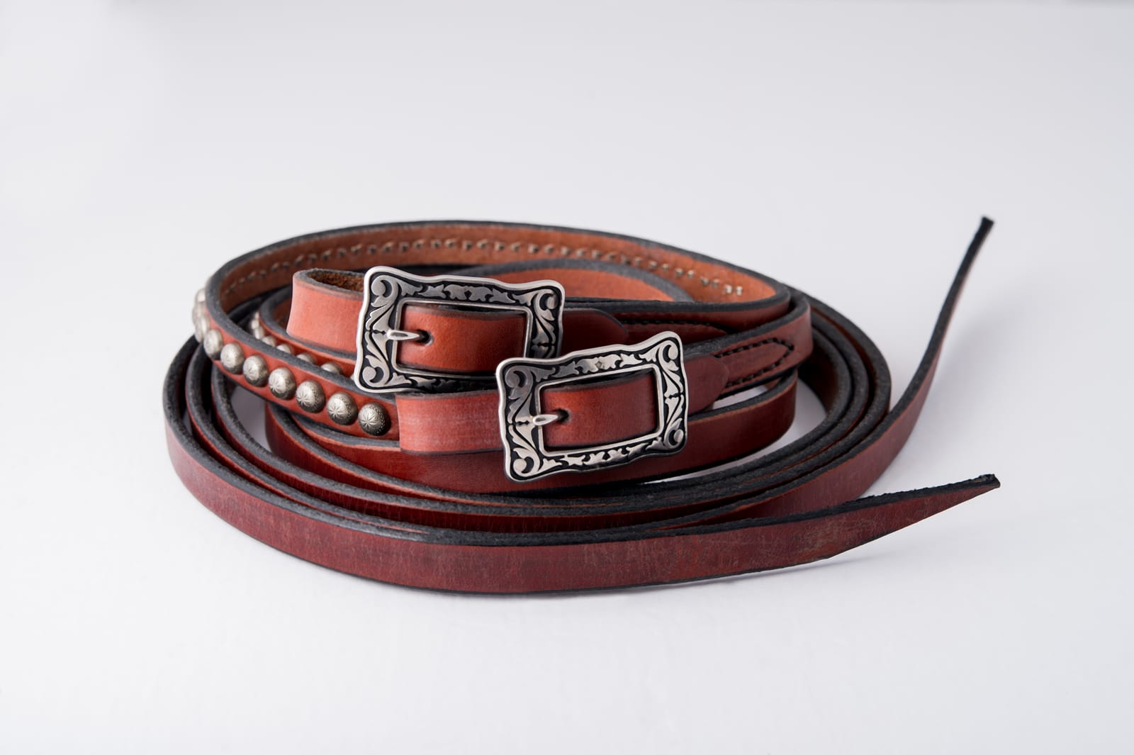 Coiled Dr. Cook Deluxe Western leather split reins with antiqued silver spots and engraved buckles