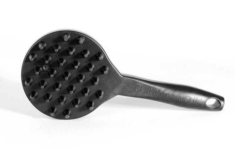 Top-down view of the Curry on a Stik massage side with cone-shaped rubber nubs and embossed branding on the handle