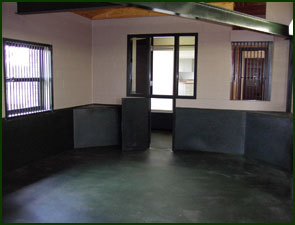 Equine stall with seamless black Equi-Turf rubber flooring and matching wall siding