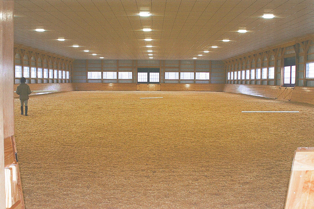 Spacious covered indoor riding arena interior outfitted with an installed Equine-Audio sound system