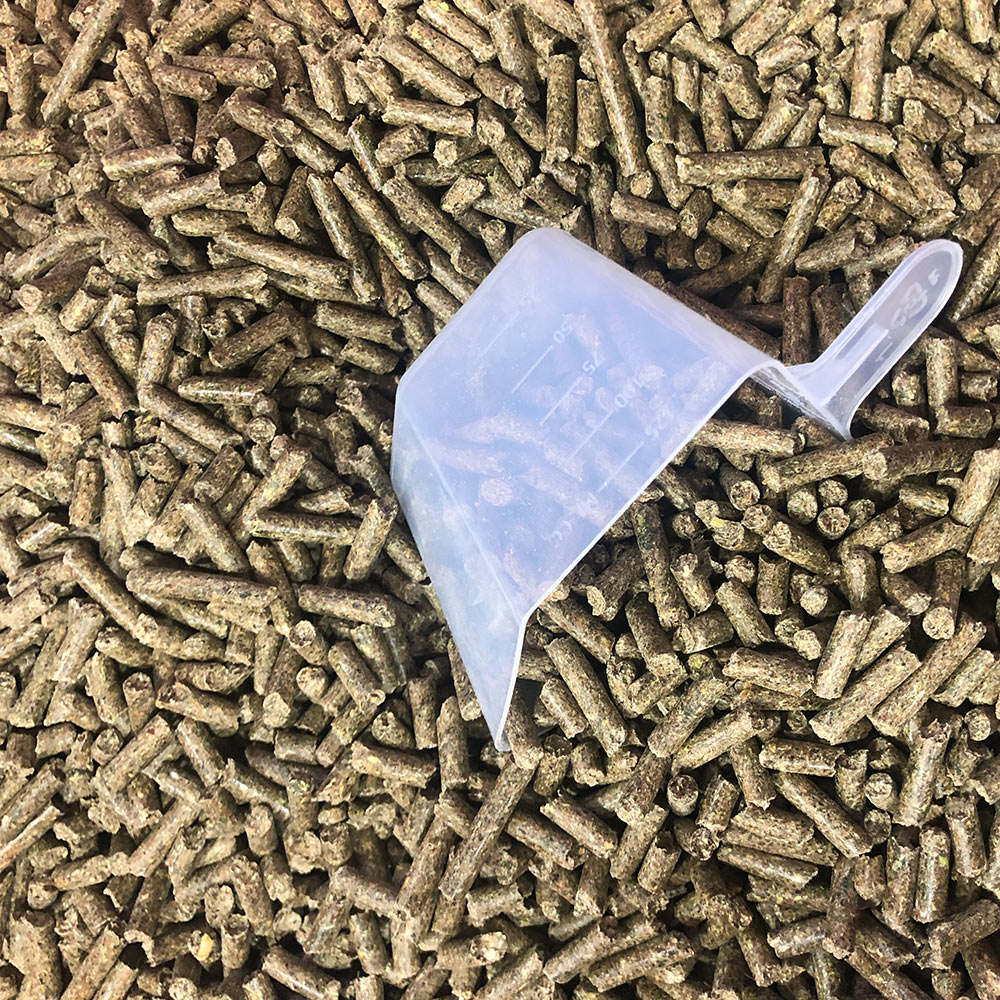 Close-up of the alfalfa-based Farrier's Magic Plus hoof pellets with measuring scoop