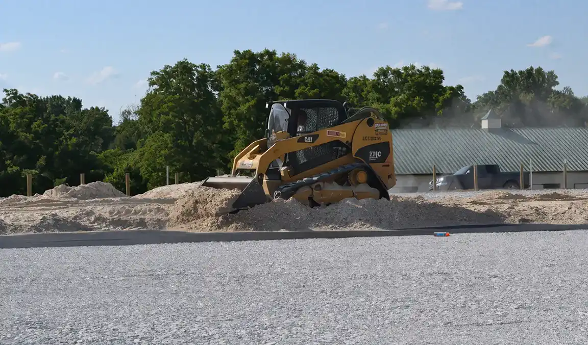 Heavy equipment preparing an equestrian arena base for FootingFirst installation