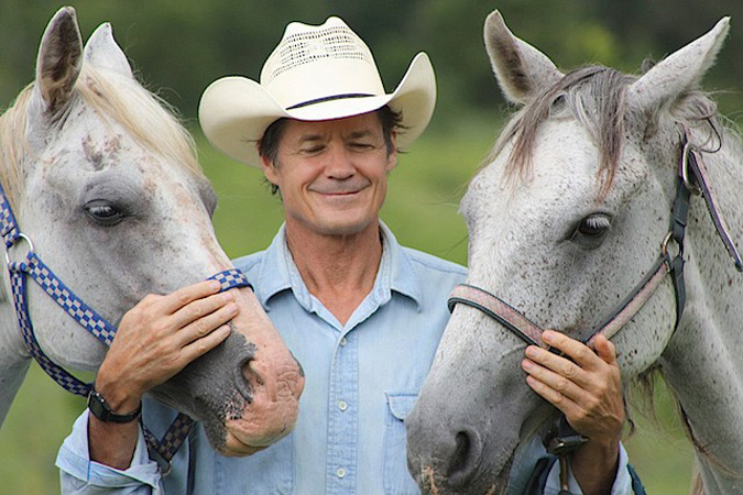 Natural horsemanship trainer Frank Bell working with two horses