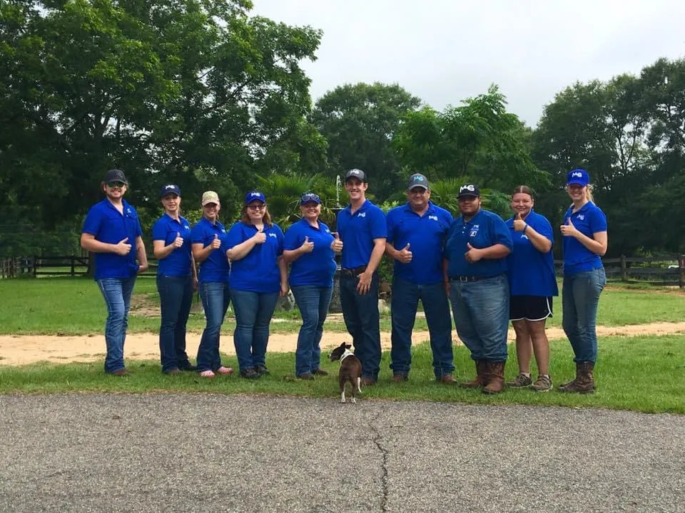 Michael Gascon and a group of Gascon Horsemanship Academy students in matching shirts giving a thumbs-up at Horse Haven Ranch