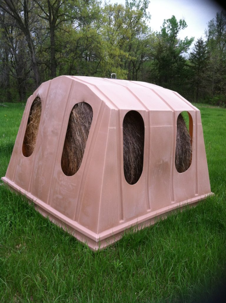 Hay Bonnet covered horse hay feeder over a round bale showing the eight feeding openings