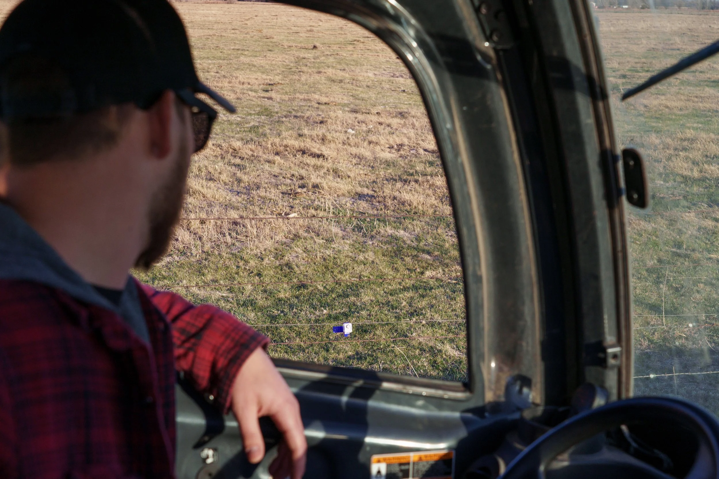 Insulights electric fence monitor installed on a wooden fence post in a pasture