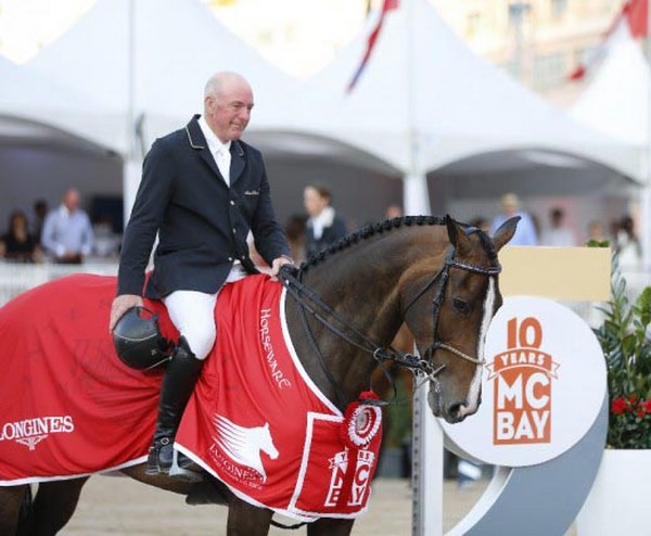 Accomplished show rider mounted on a decorated competition horse at a major event