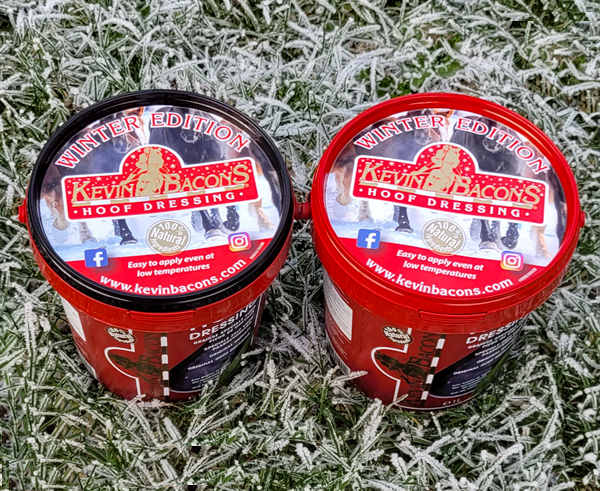 Two tubs of Kevin Bacon's Hoof Dressing Winter Edition resting on frosted winter grass