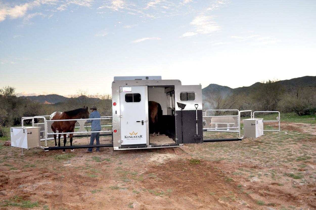 Kingstar Trail Lodge Edition horse trailer with both power corral wings fully deployed at a desert campsite at dusk
