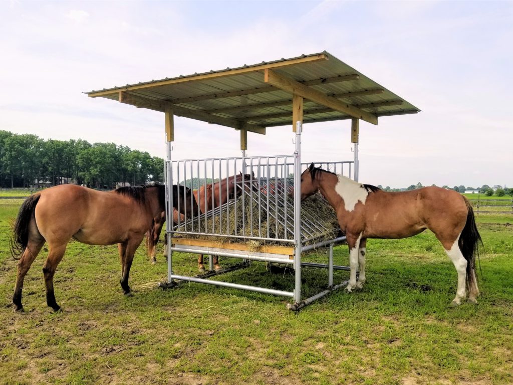 Klene Pipe Structures H-8 patented HaySaver horse hay feeder with fold-down grills holding a round bale