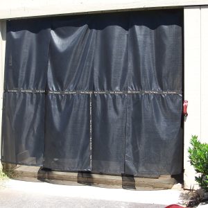 Kool Kurtains black cooling panels hung across a horse barn aisle