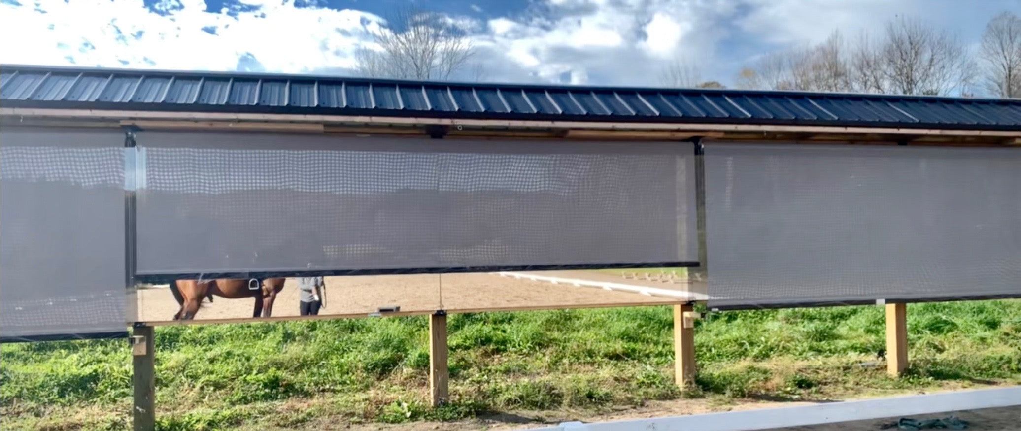Outdoor arena LiteMirror panels protected by roller shade coverings against weather