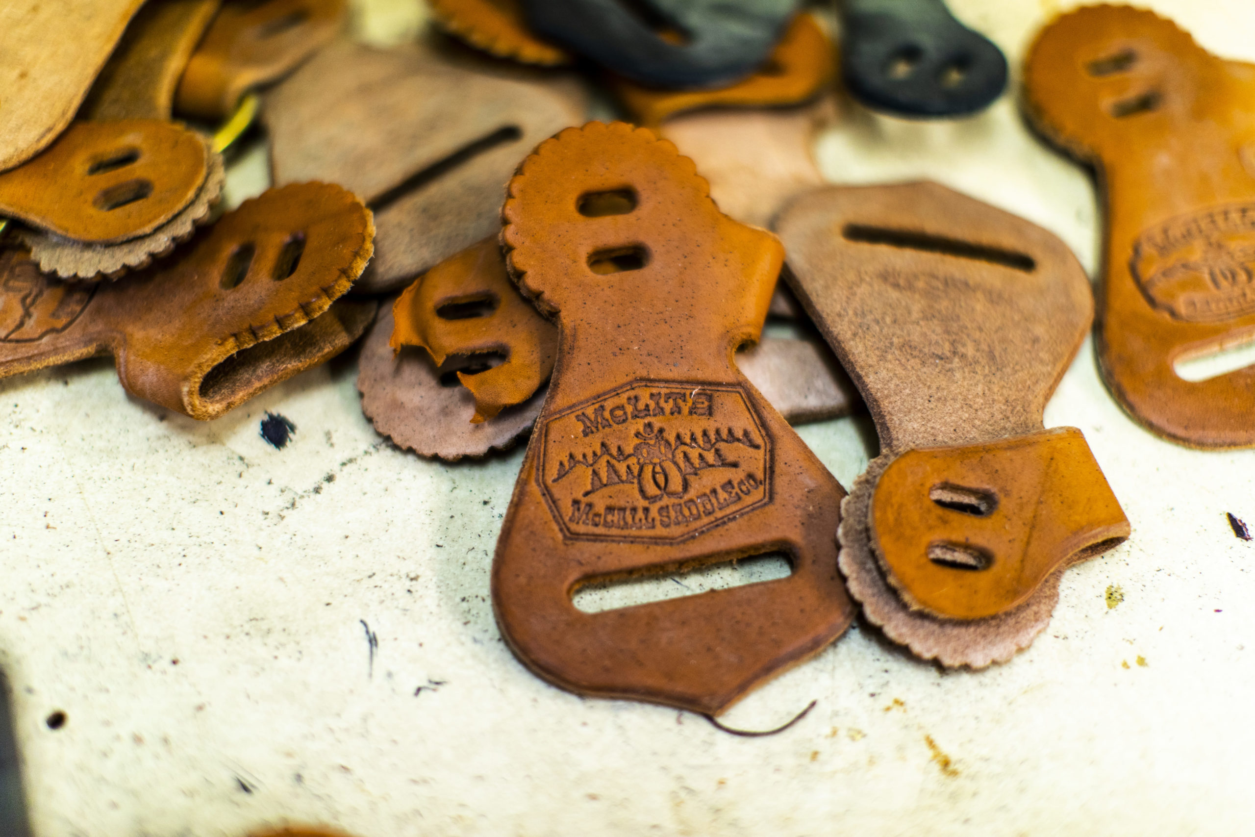 Hand-tooled and stamped leather components carrying the McCall maker's mark, ready for assembly