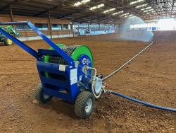 Micro Rain MR32 traveling sprinkler watering a horse arena for dust control