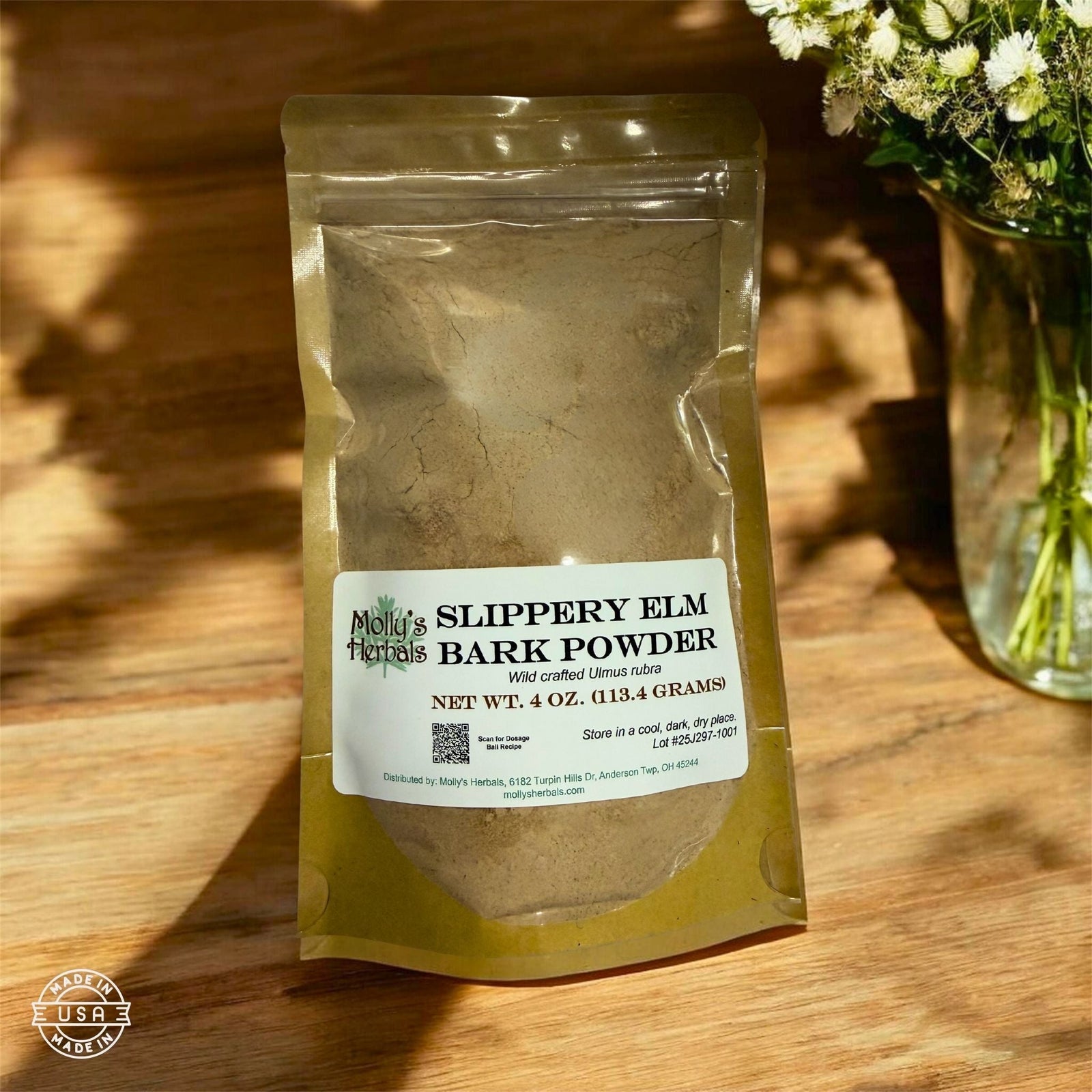 Molly's Herbals herbal powder pouch in natural light beside fresh wildflowers