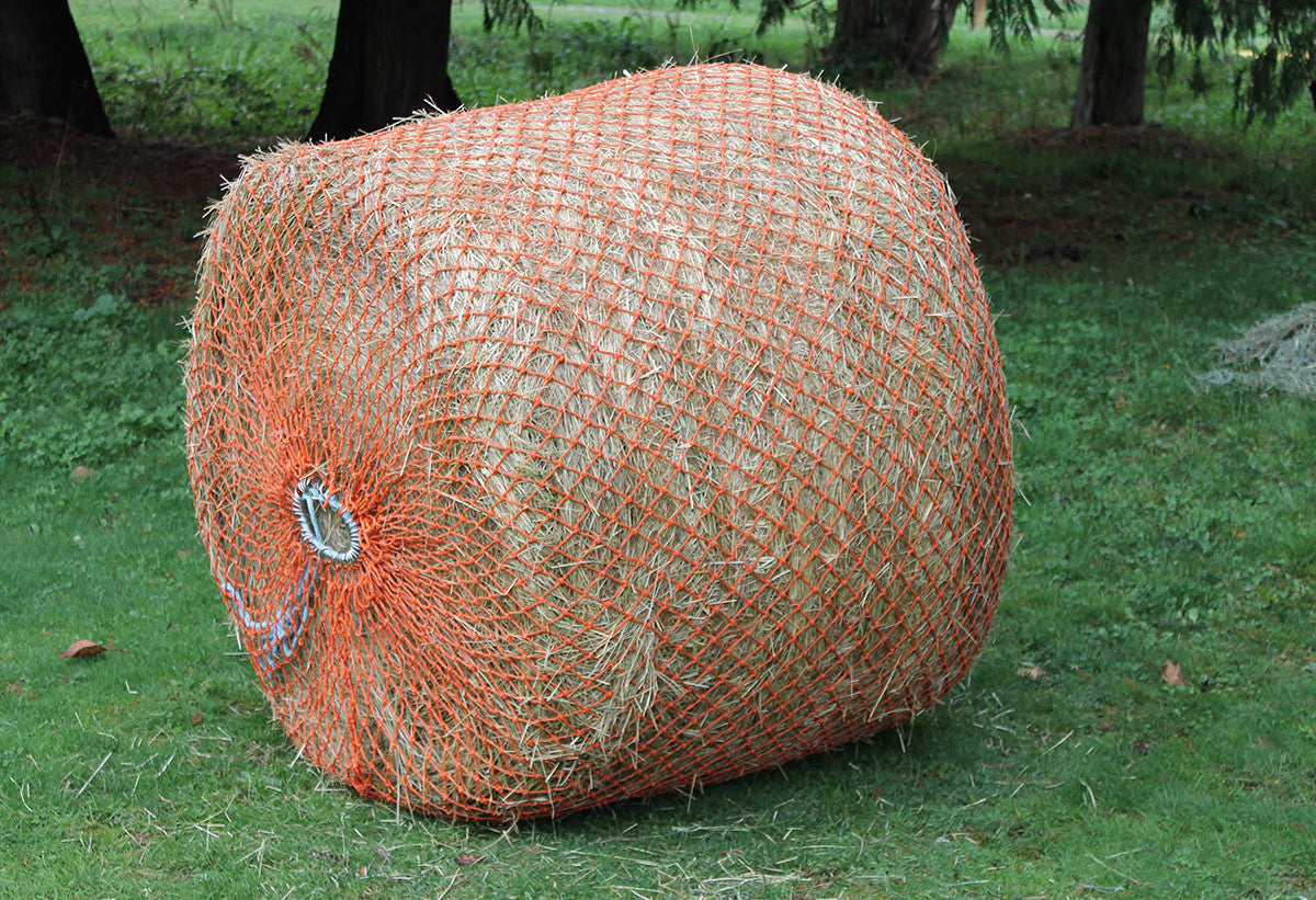 Orange Slow Feeder 4 by 4 round bale net wrapped around a hay bale