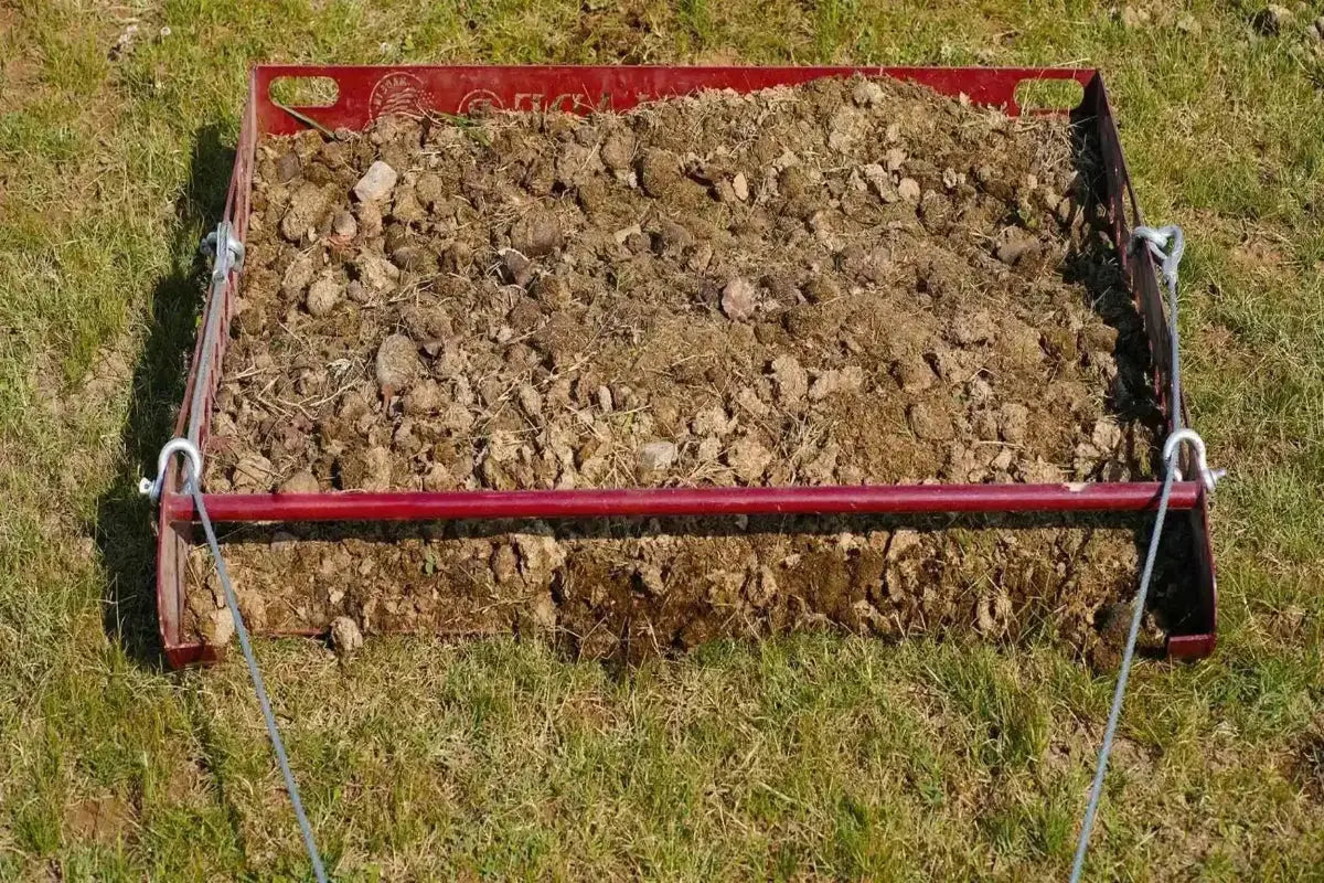 Paddock Blade being towed behind an ATV cleaning a horse pasture