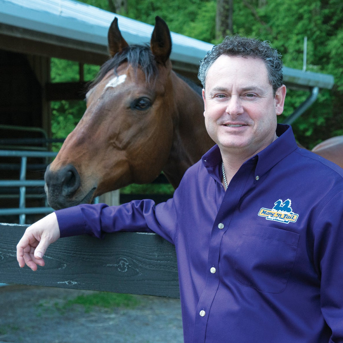 Handler standing alongside a well-groomed horse outdoors with a healthy, shining coat