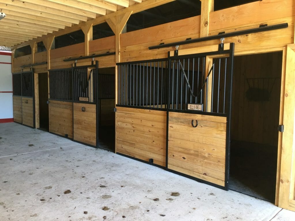 StallWorks galvannealed steel horse stall fronts installed in a barn aisle