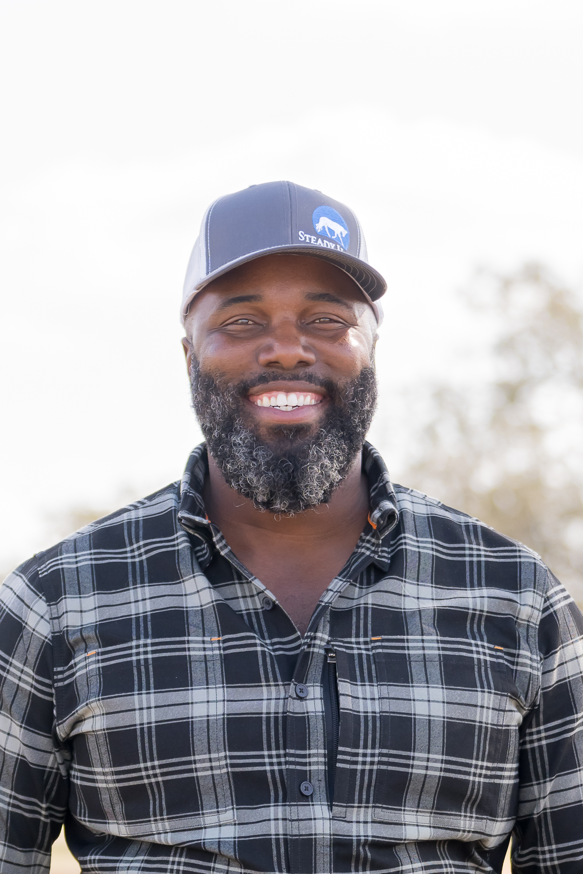 Portrait of Steady Horse founder and clinician Noah Tillman-Young smiling at the ranch