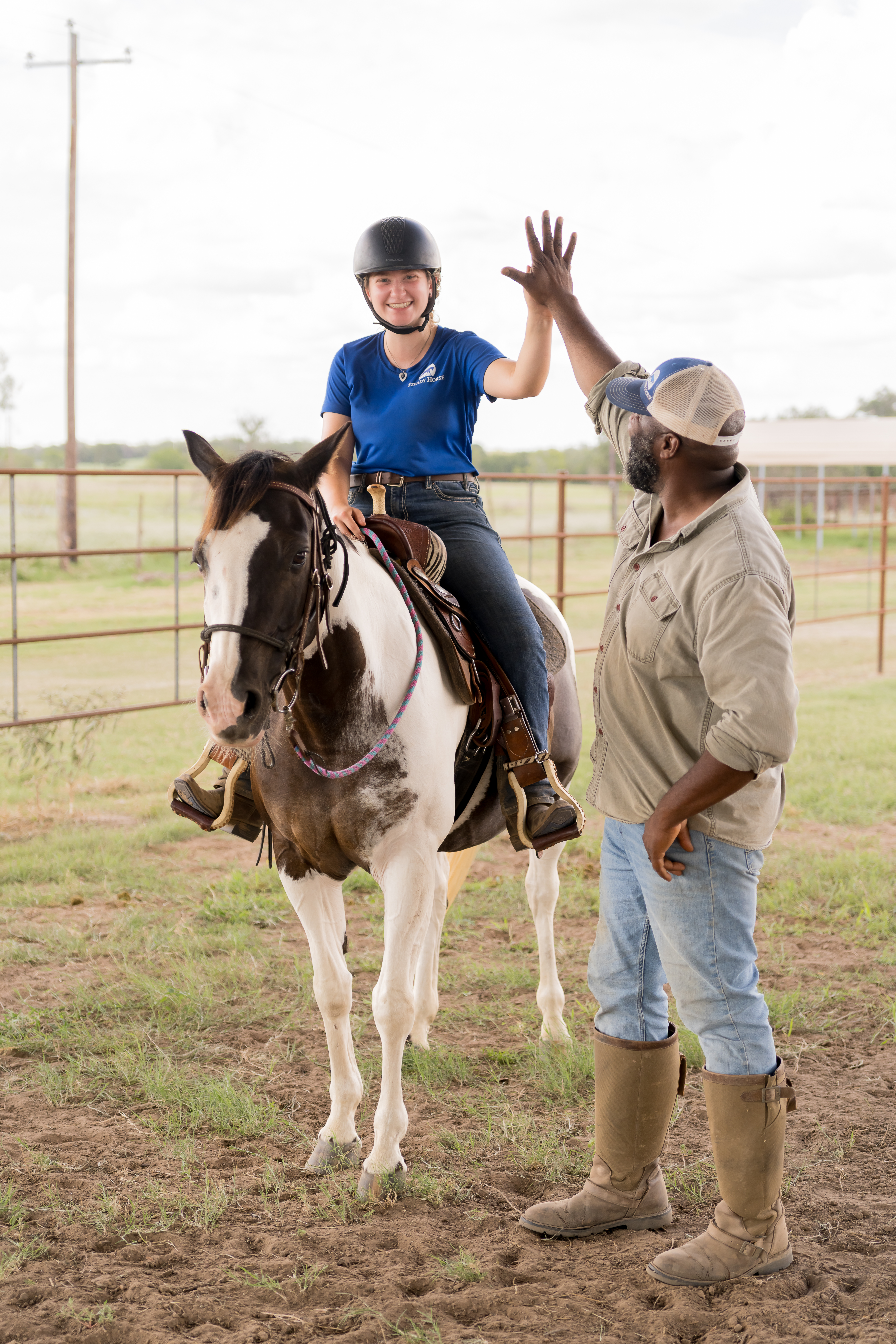 Noah Tillman-Young high-fiving a young rider during a Steady Horse confidence lesson