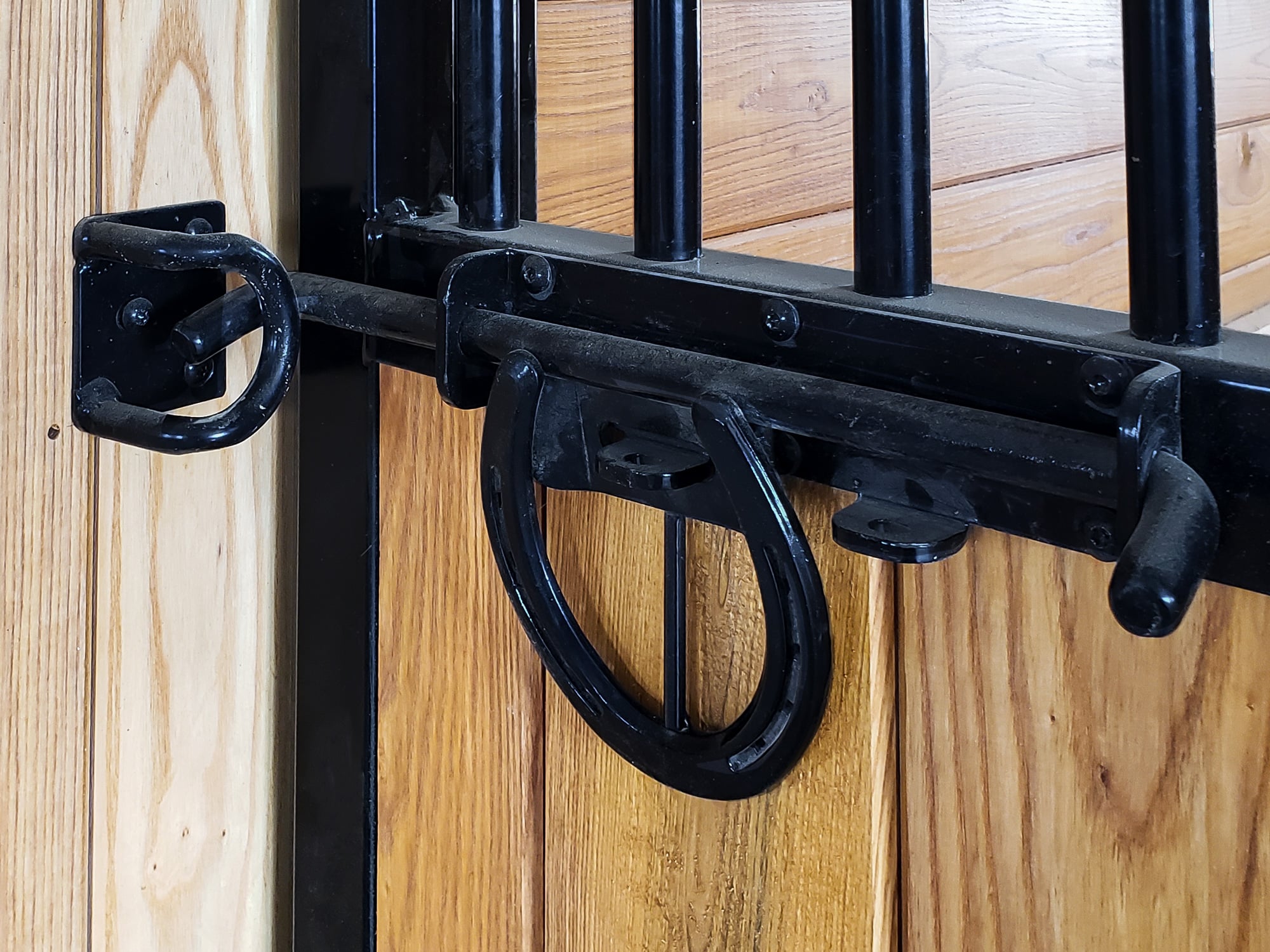 System Equine horseshoe door latch in black powder-coated finish for horse stall hardware