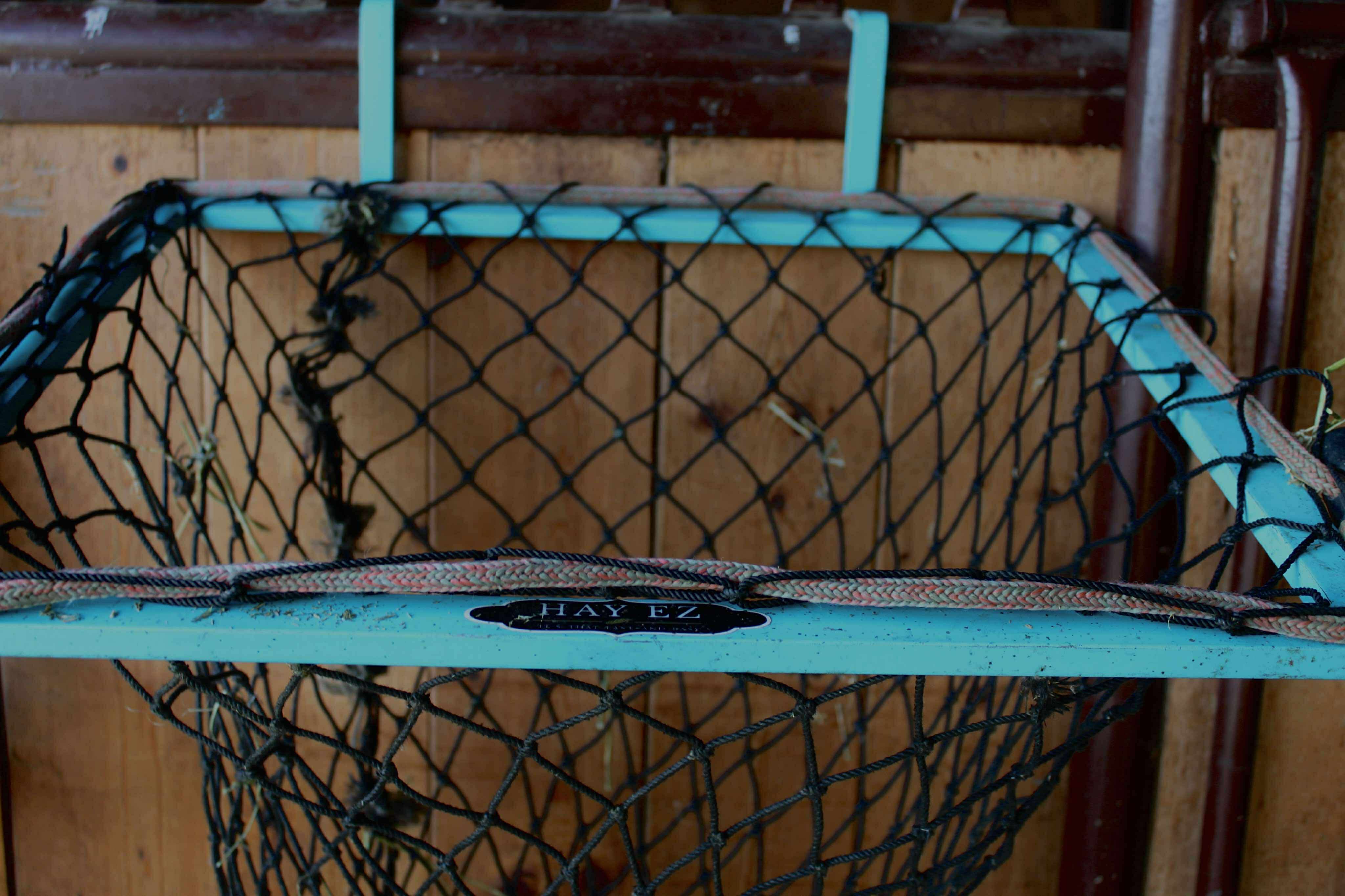 Close-up of a branded Hay-EZ stand with a hay net attached to the frame