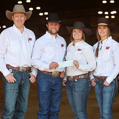 University of Montana Western natural horsemanship team in matching shirts at a competition