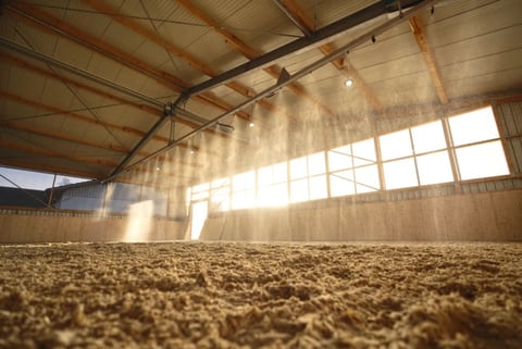 Equine Irrigation — overhead misting system watering the footing of an indoor horse arena